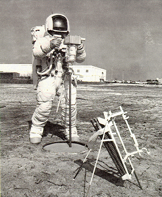 Při misích Apollo 15, 16 a 17 měli astronauti k dispozici vrtačku schopnou odebírat jádrové vzorky o průměru dvou centimetrů.. Tato fotografie vznikla ještě při nácviku na Zemi.