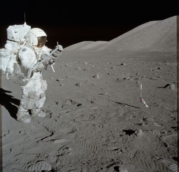 Harrison Schmitt při kosmické vycházce Apolla 17 pracuje s nástrojem pro odběr vzorků.