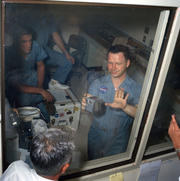 Fotograf Terry Slezak v karanténě ukazuje ruku znečištěnou od měsíčního prachu, ve druhé pak drží kazetu s filmem