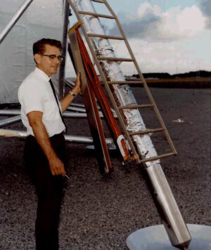 Technik Dave McCraw demonstruje odstranění krytu pouzdra nesoucího vlajku na lunárním modulu; zároveň je jasně vidět, kde a jak přesně byla vlajka na žebříku modulu umístěna.